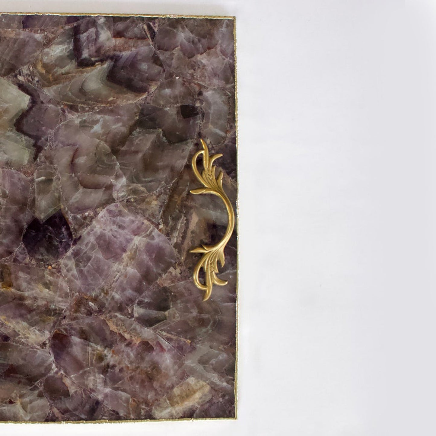 Close-up of a decorative purple stone tray with ornate gold handles from The Tangerine Store