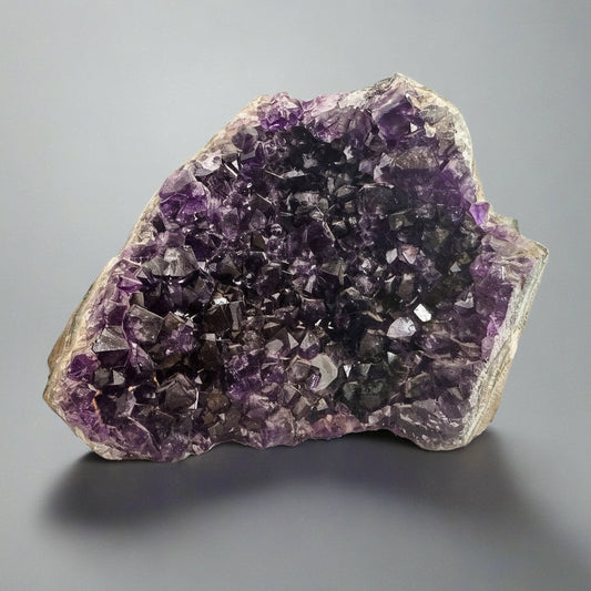 Blackbird & Sage Jewelry Studio amethyst geode decor piece with deep purple crystals on gray background
