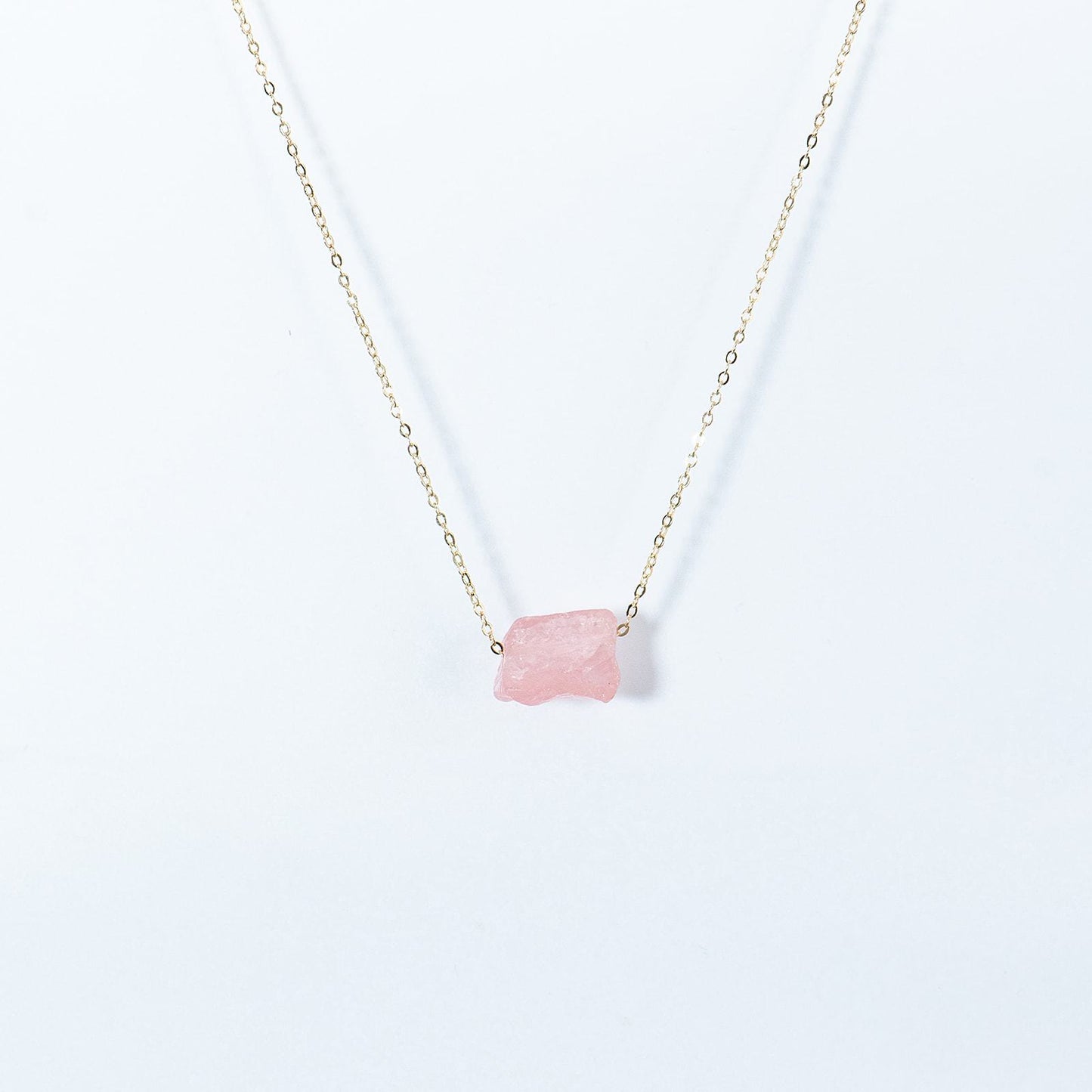 Kuratif handmade crystal necklace with delicate gold chain and pink raw crystal pendant