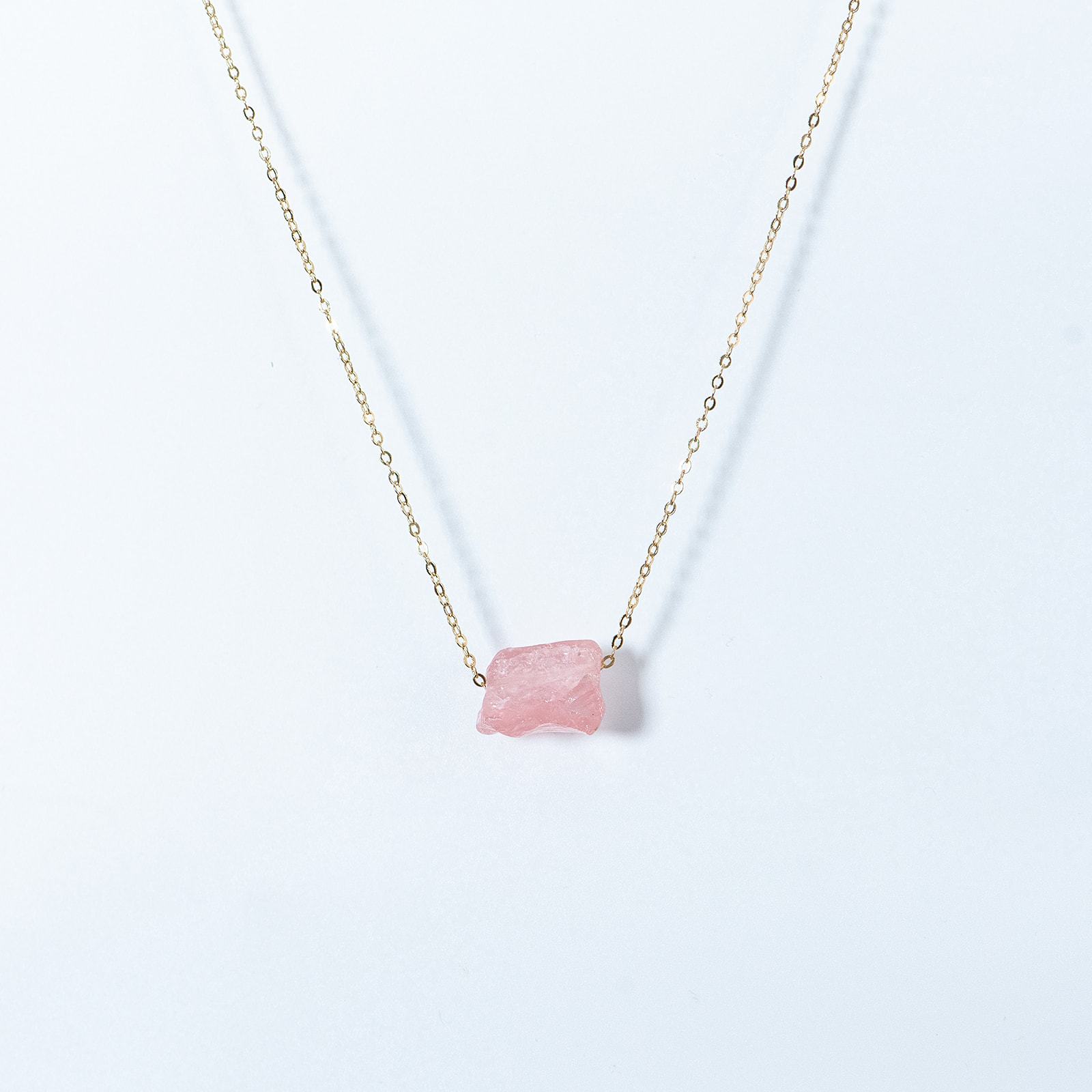 Kuratif handmade crystal necklace with a delicate rose quartz pendant on a gold chain