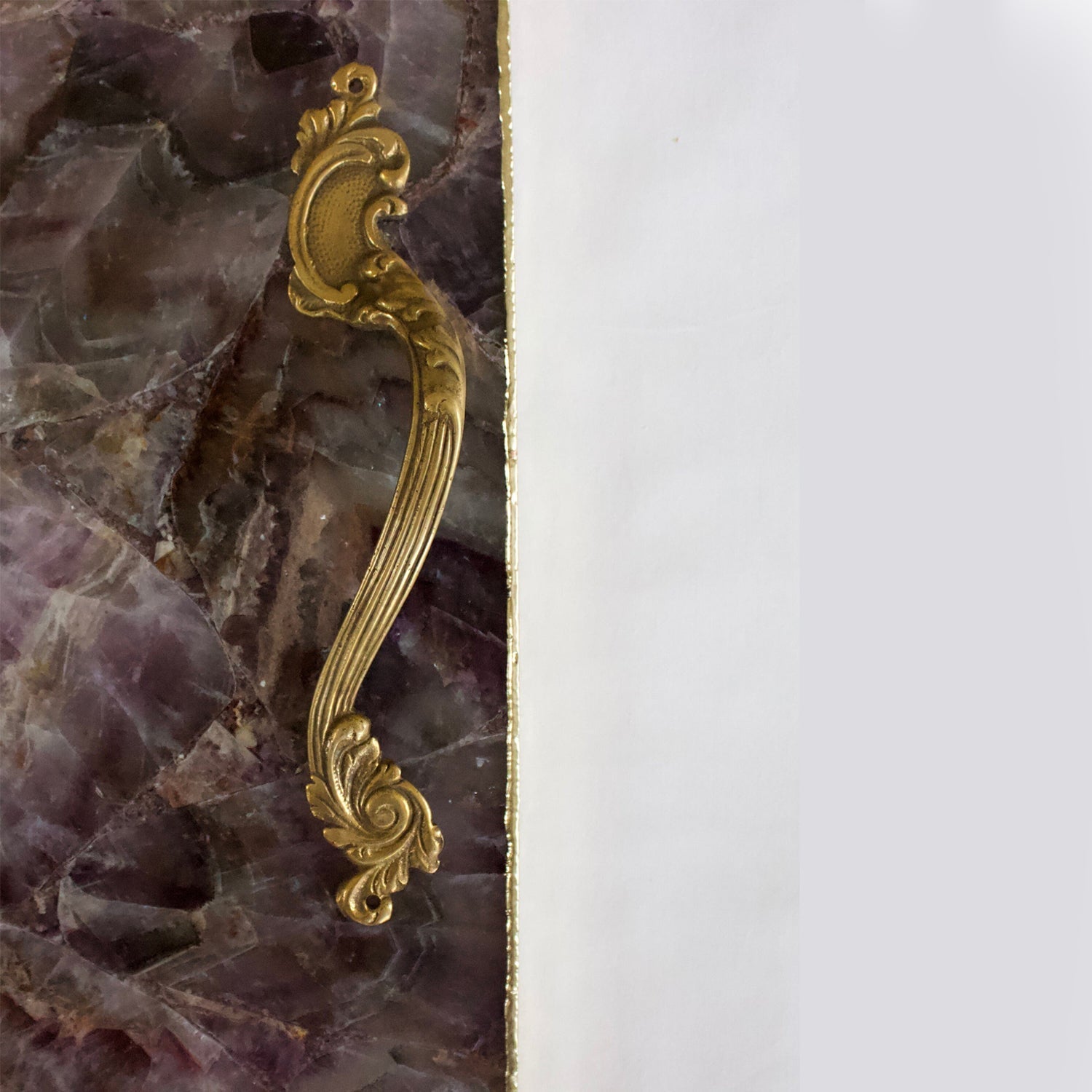 Luxury stone serving platter with a gold ornate handle and contrasting purple and white stone design